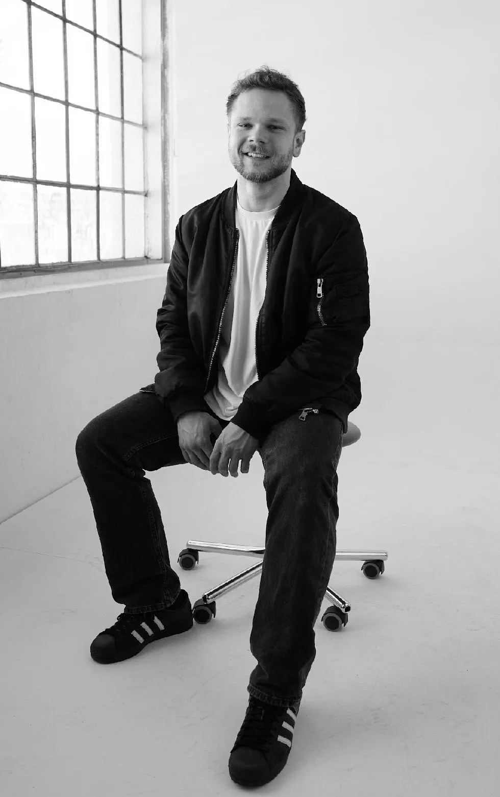 Patrick Rigl, full-body black and white studio portrait